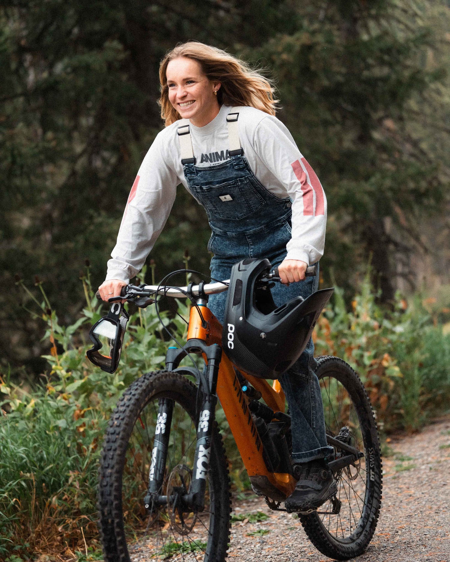 Woman wearing Indigo Marble denim overalls on a mountain bike