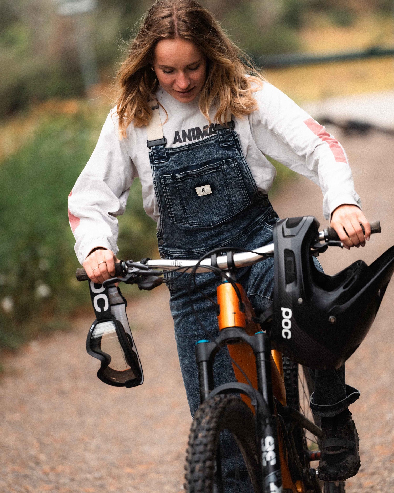 Woman wearing Indigo Marble denim overalls on a mountain bike