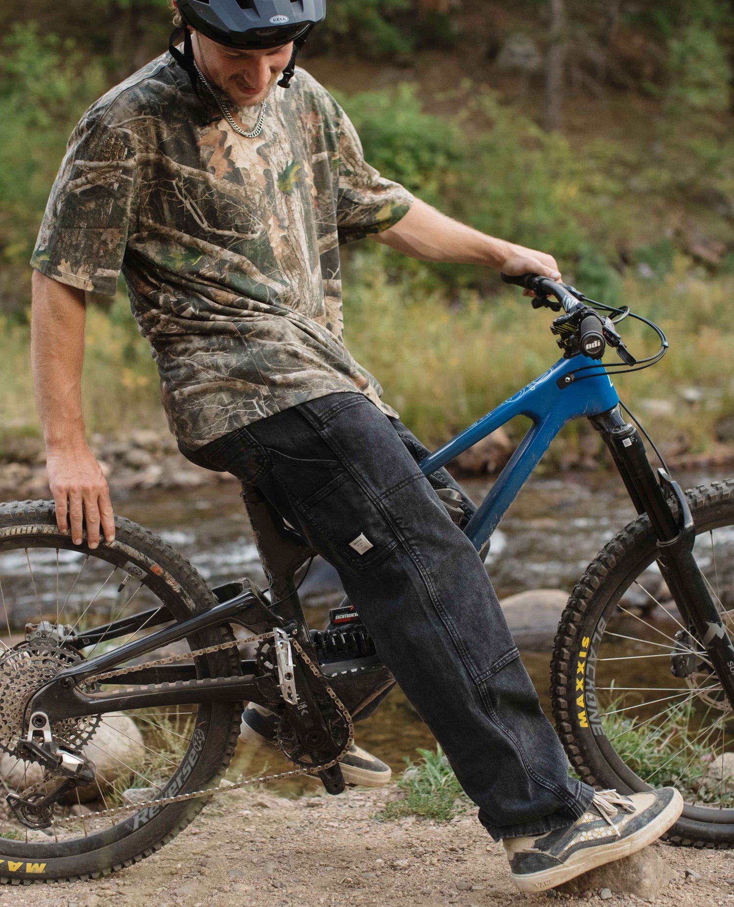 Man with a blue mountain bike in a natural setting