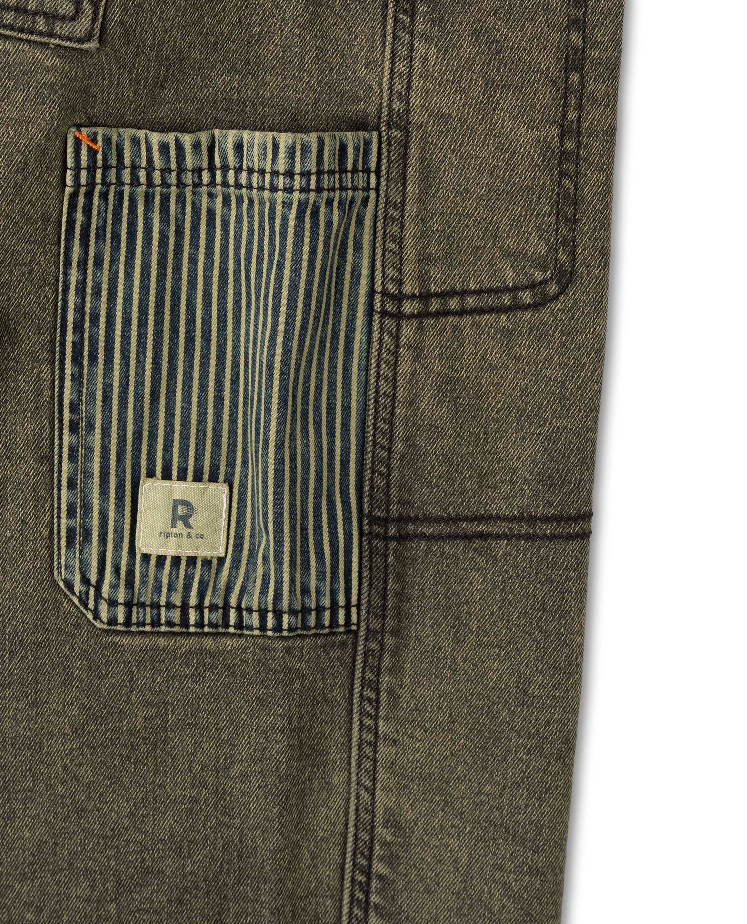 Close-up of a pocket on a green denim jacket with a brand label.
