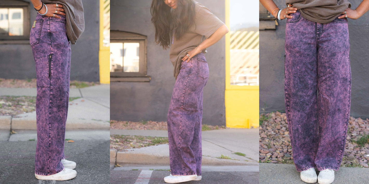 Purple patterned pants worn by a person on a sidewalk with a building in the background.