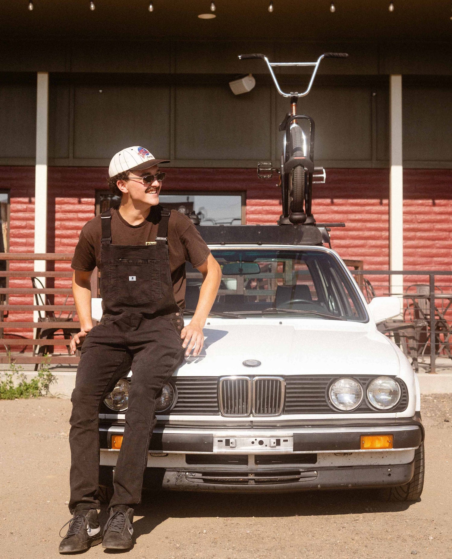 Man sitting on a BMW in Diesel Overalls. 