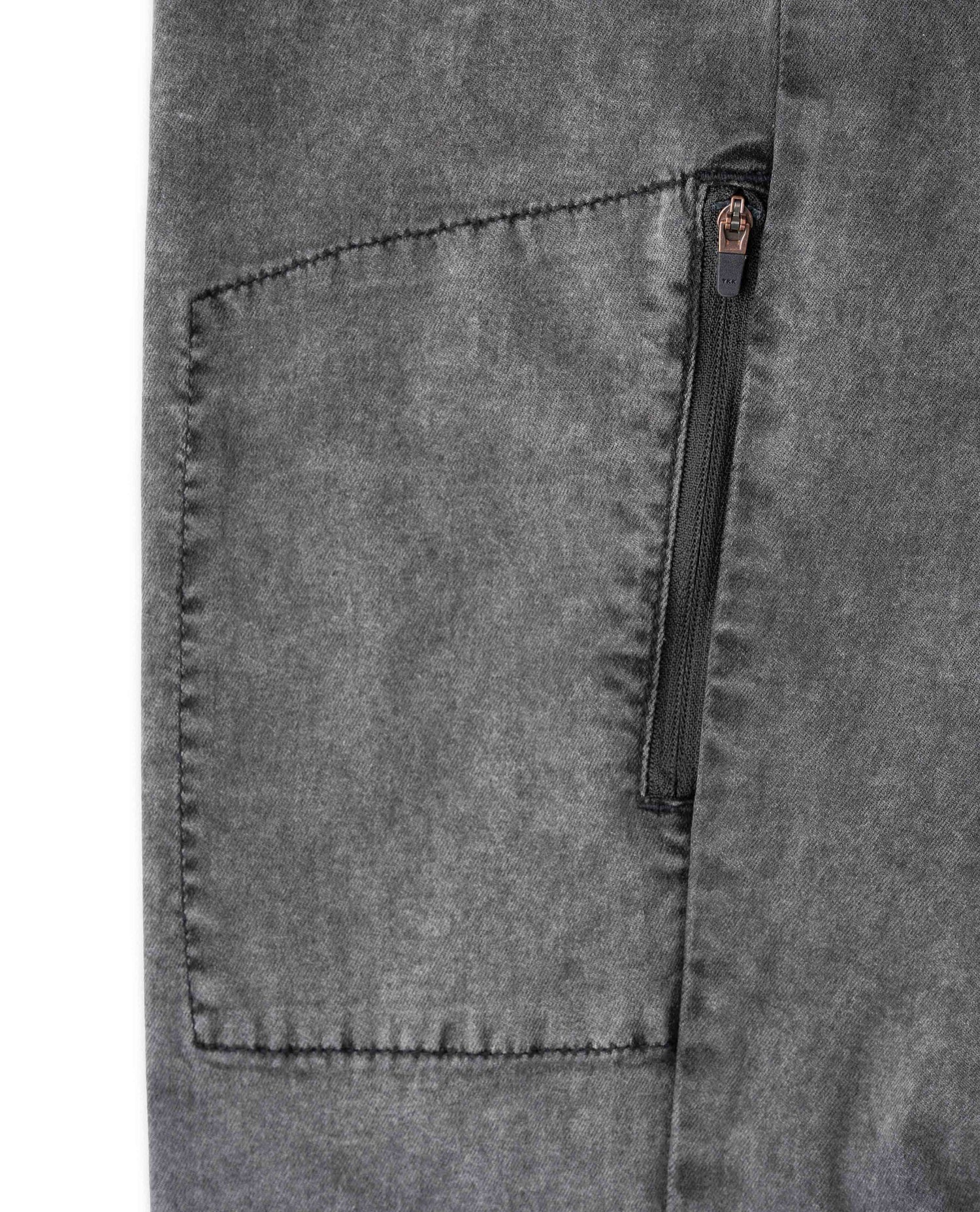 Close-up of a gray pocket with a zipper on a garment.
