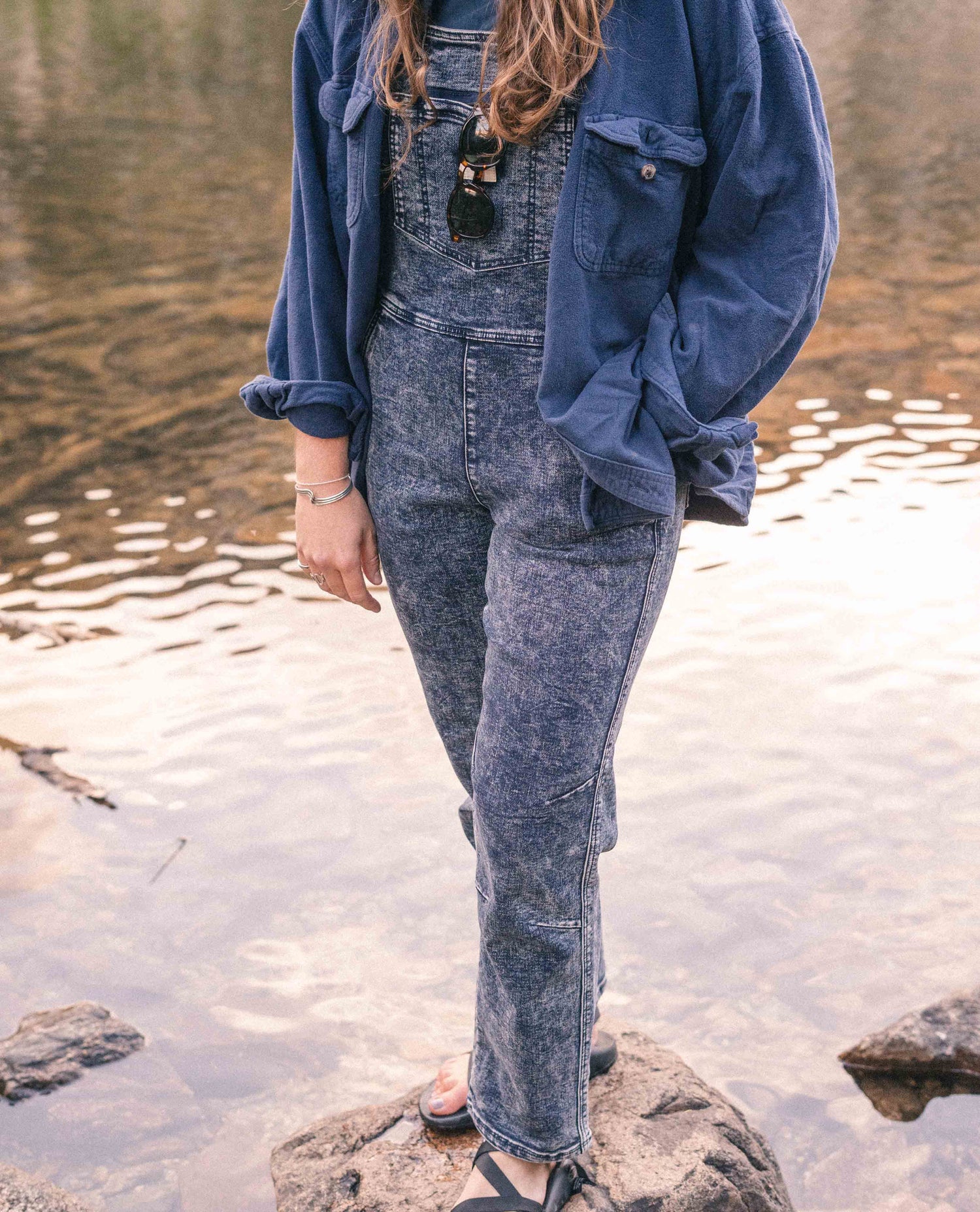 Woman wearing Indigo Marble denim overalls