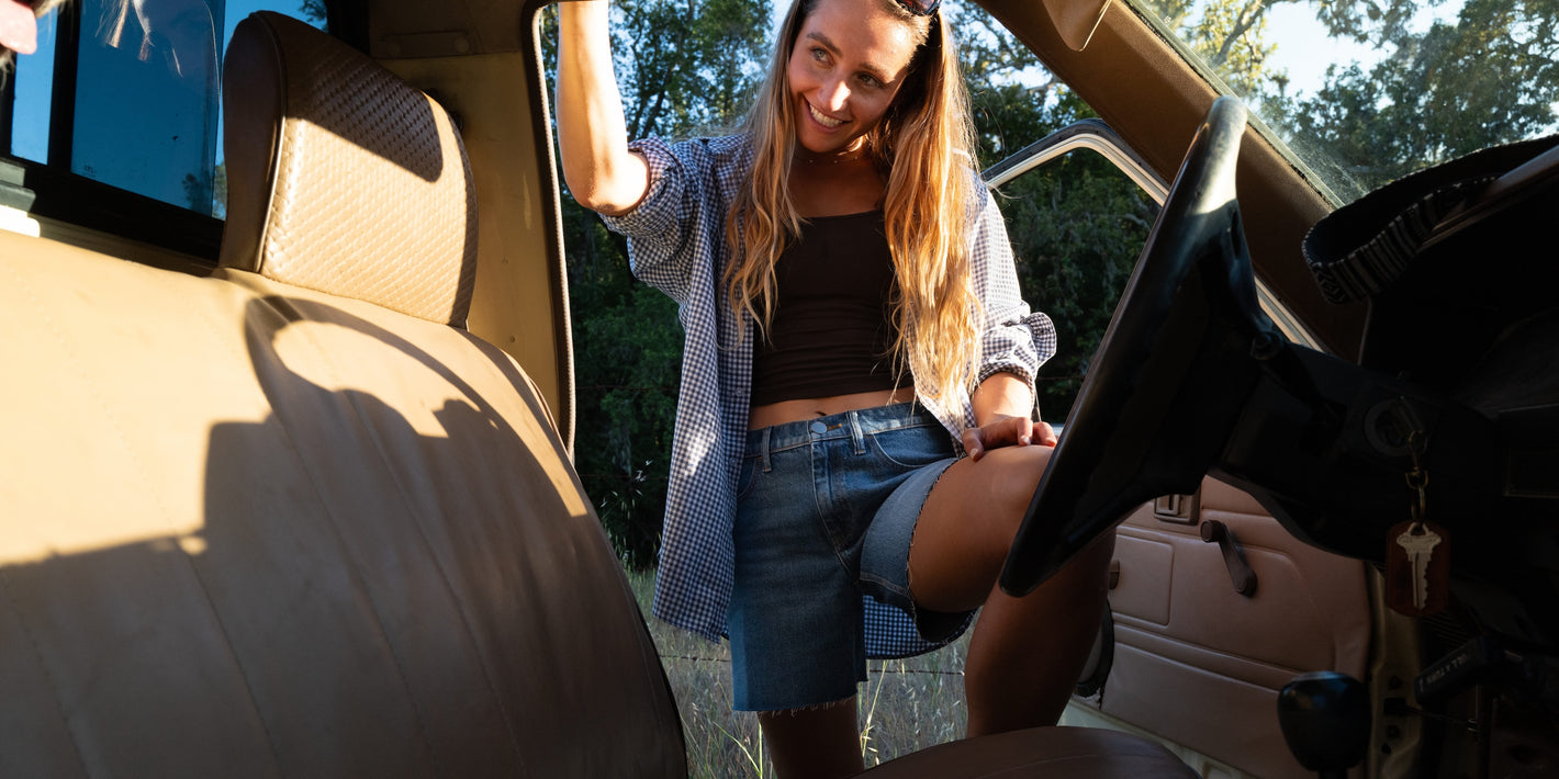 Woman getting into a car with a scenic background