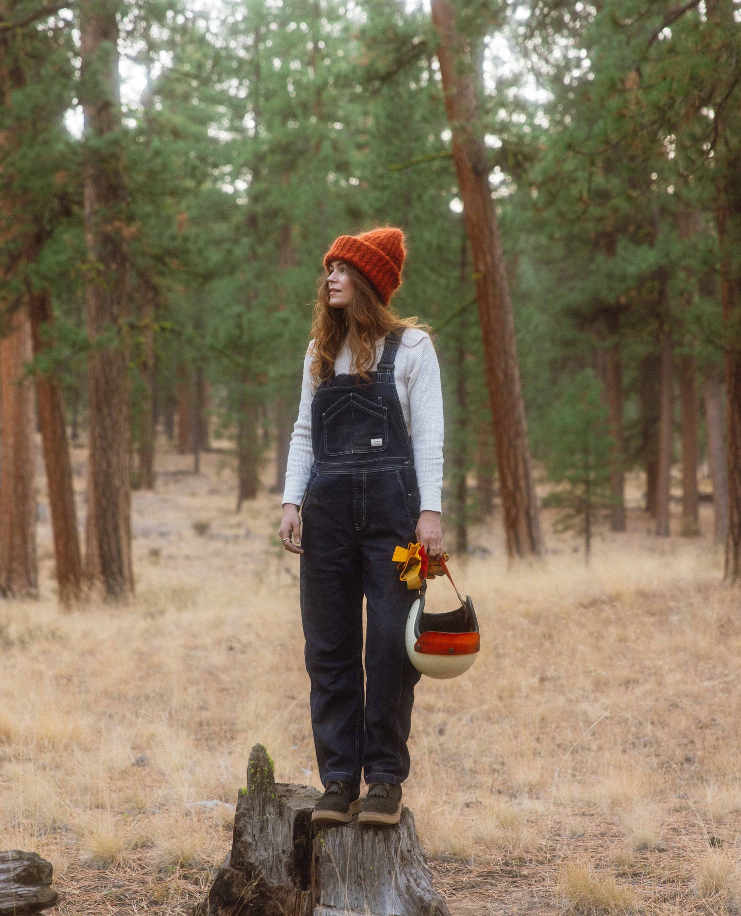 Alex wearing Starving Jartist Overalls on a stump