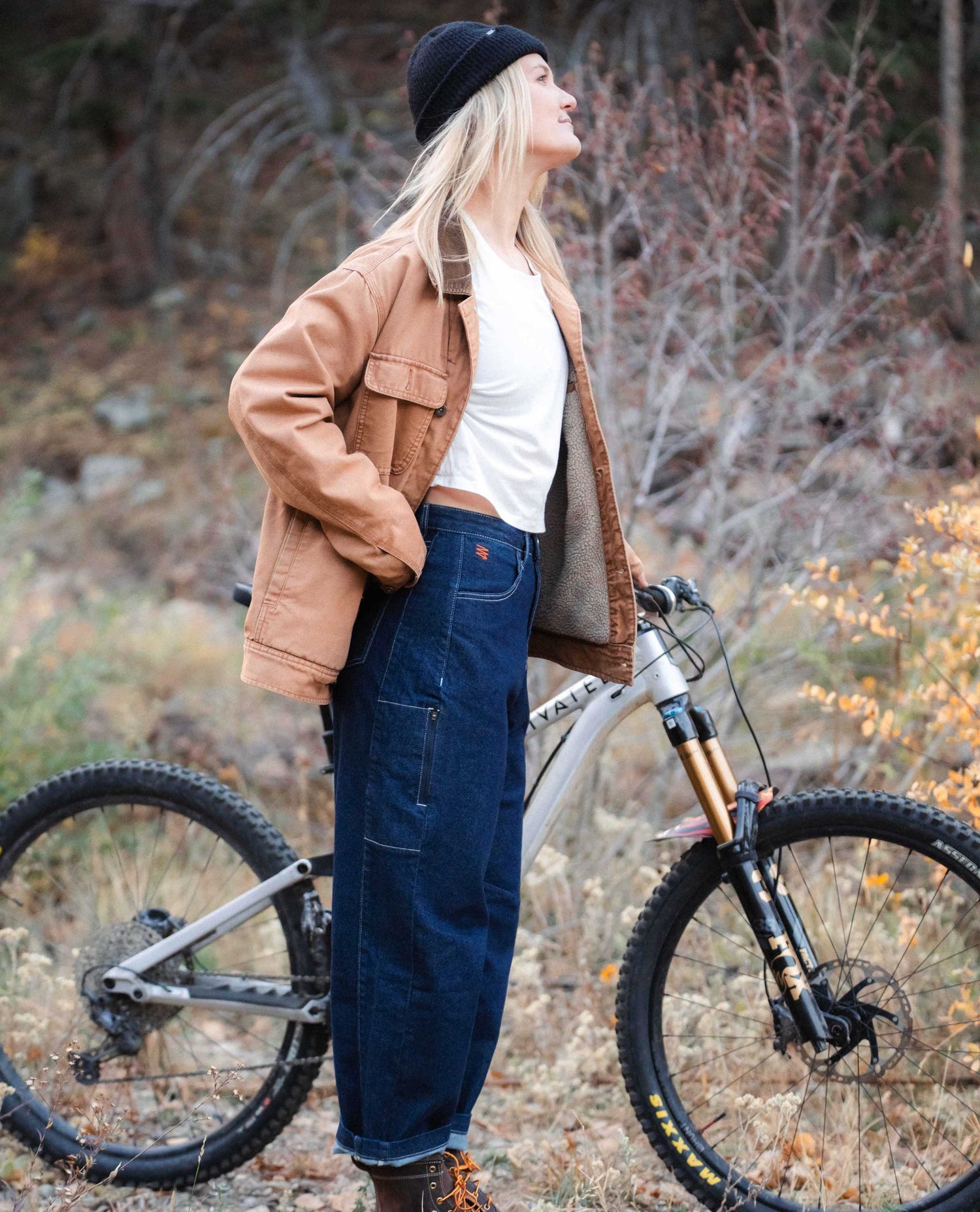 Woman standing with her mountain bike in her Tuxedo Ripton Jantalones.