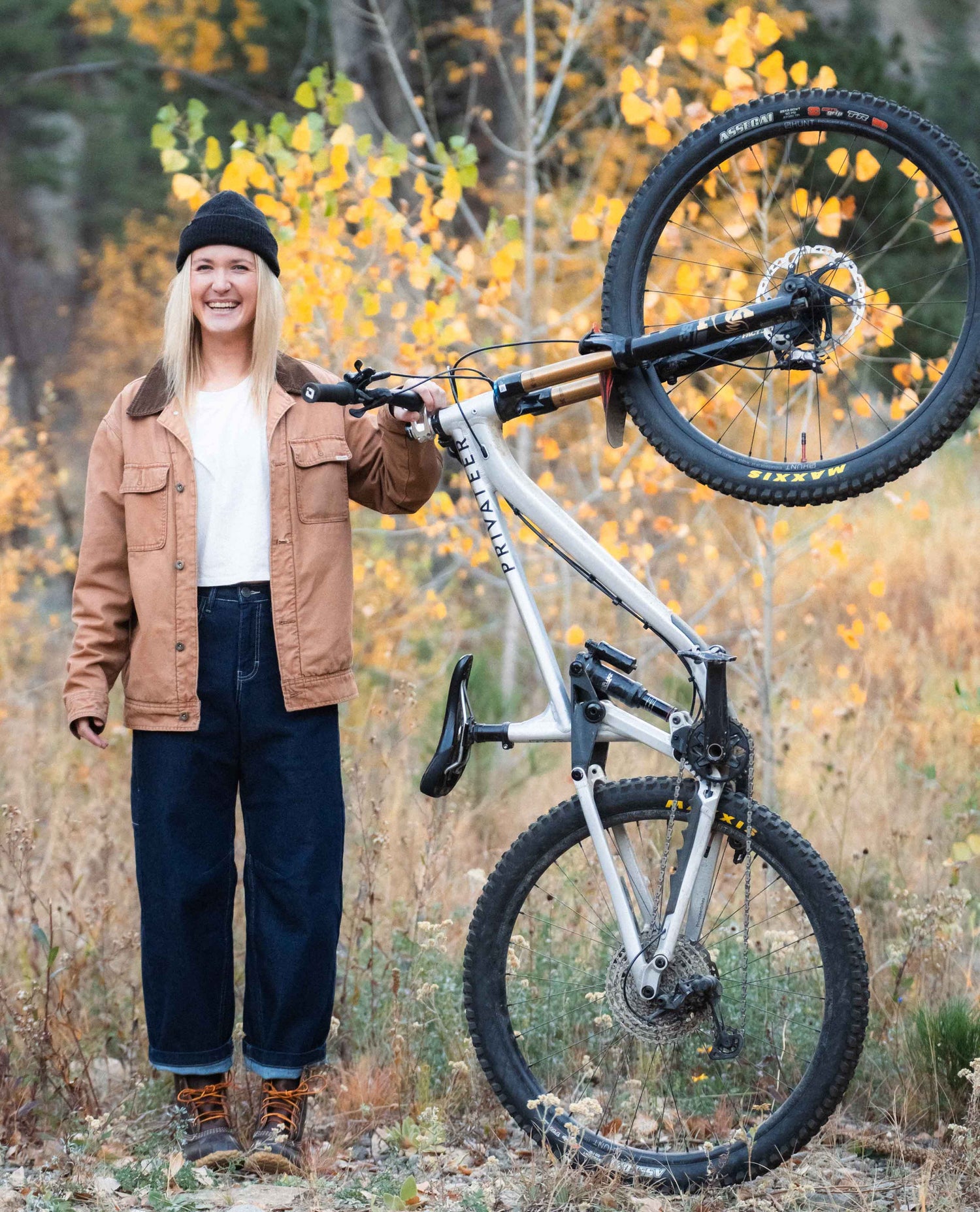 Woman standing with her mountain bike in her Tuxedo Ripton Jantalones.