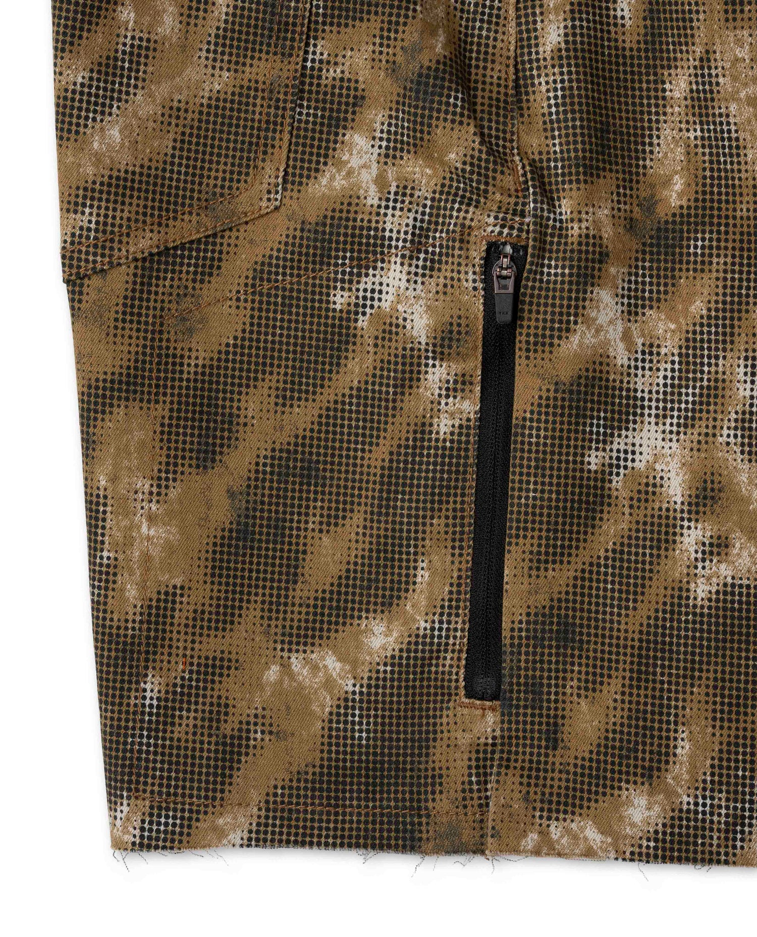 Close-up of a camouflage-patterned fabric with a zipper