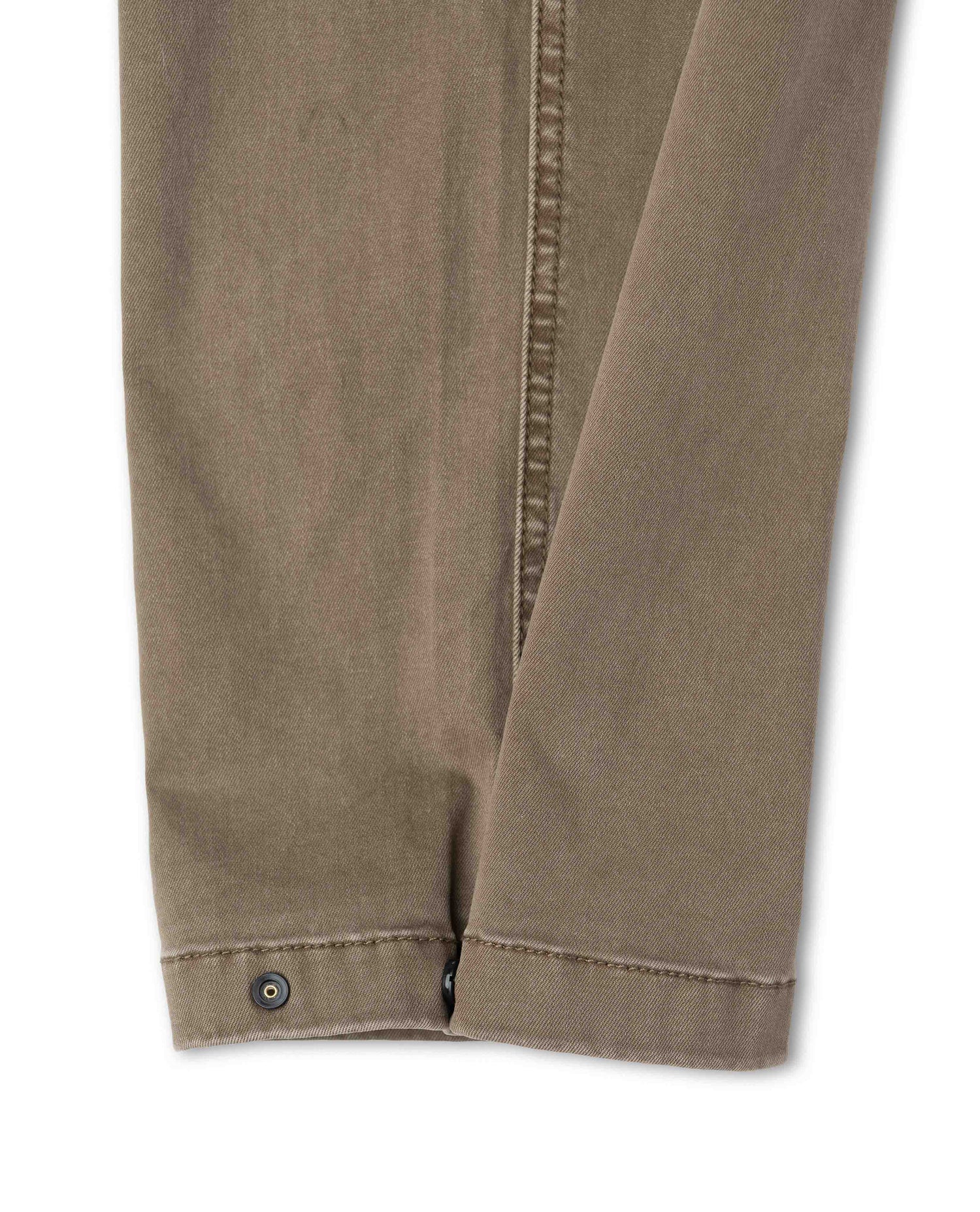 Close up of snap closure on brown pants on white background