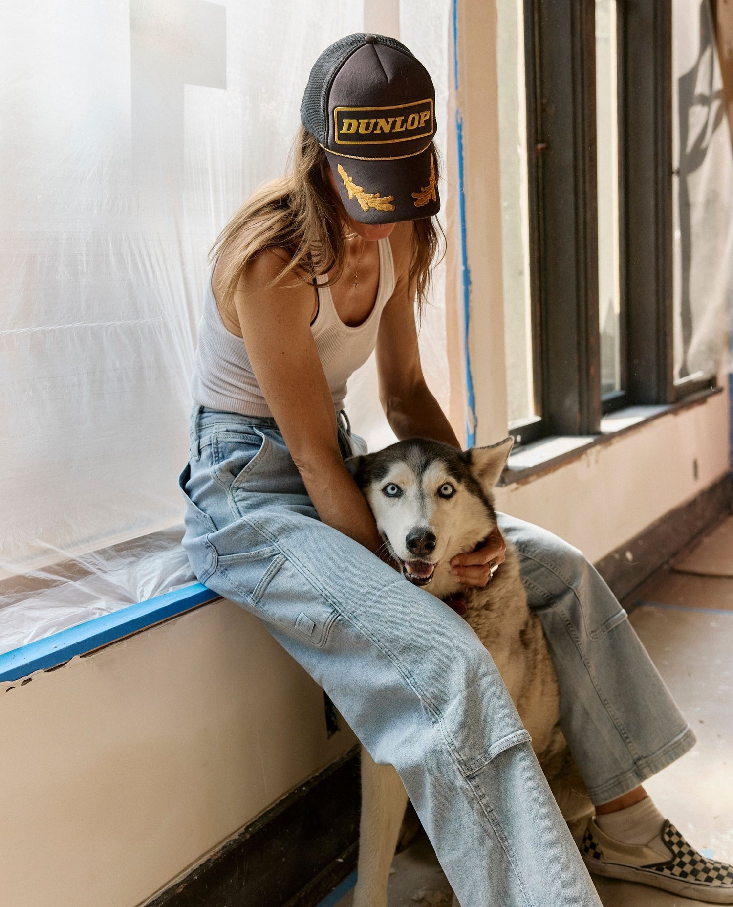Woman sitting with a dog inside a building under renovation