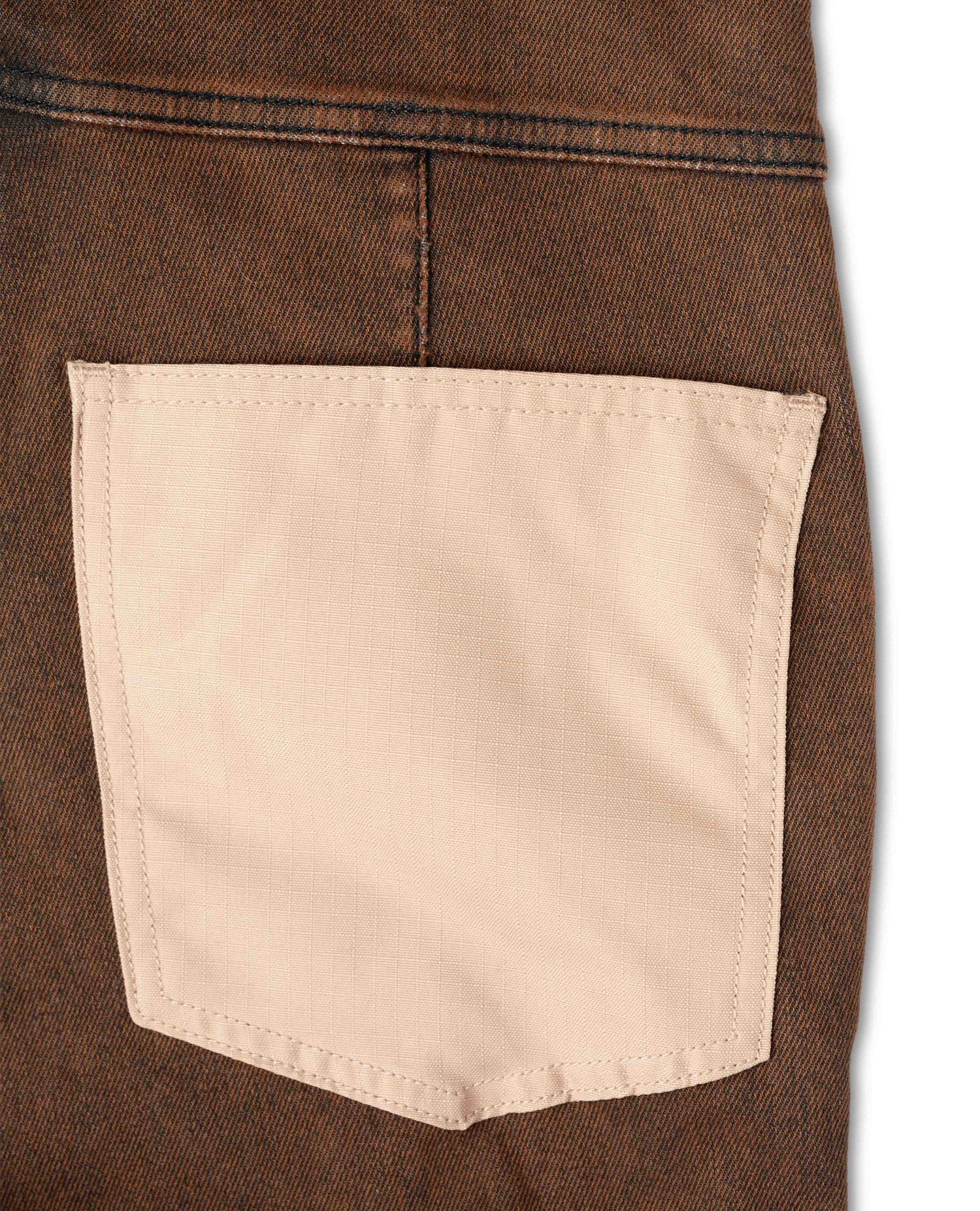Close-up of a brown denim jacket with a beige pocket on a white background