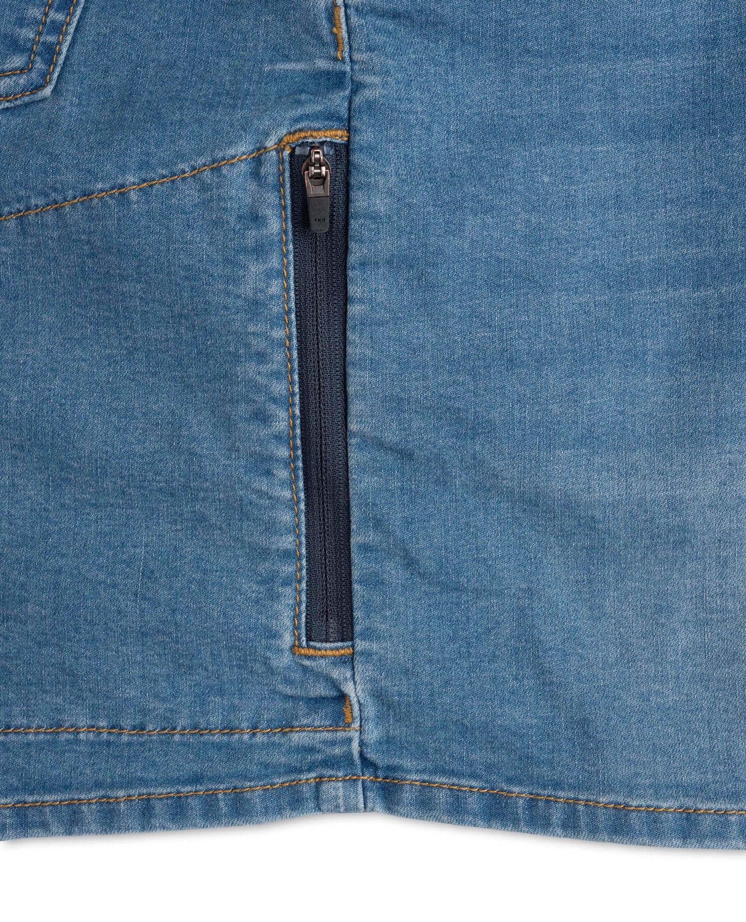 Close-up of a blue denim pocket with a zipper on a white background