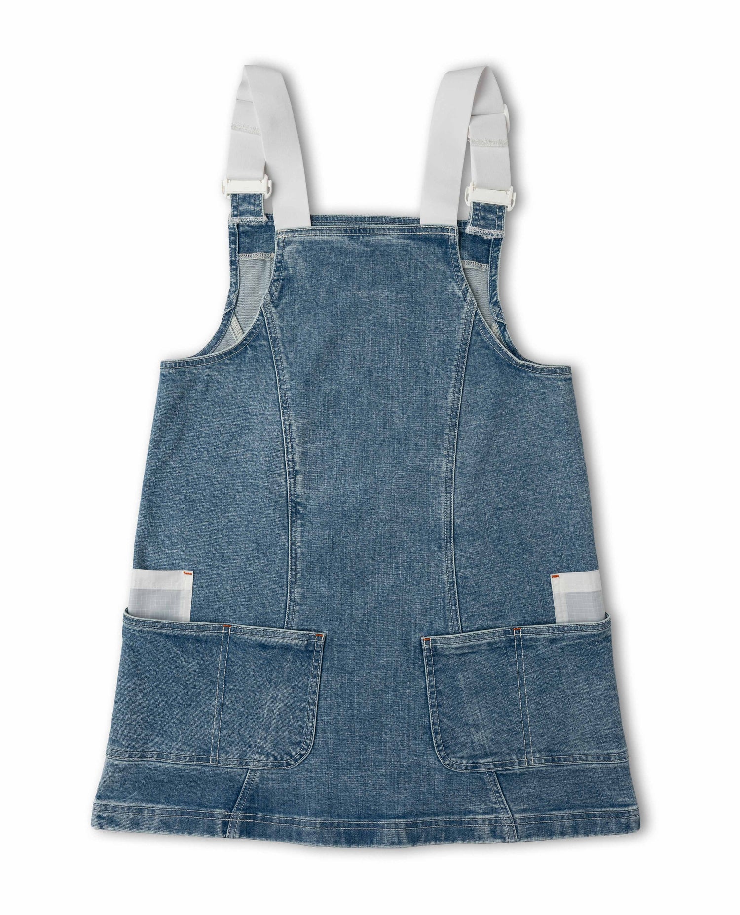 Blue denim pinafore dress with white straps on a white background