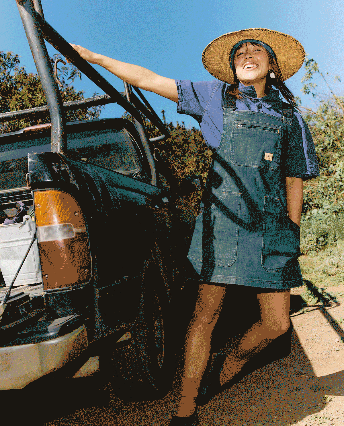 GIF of a cool lady wearing our denim dress with a sun hat