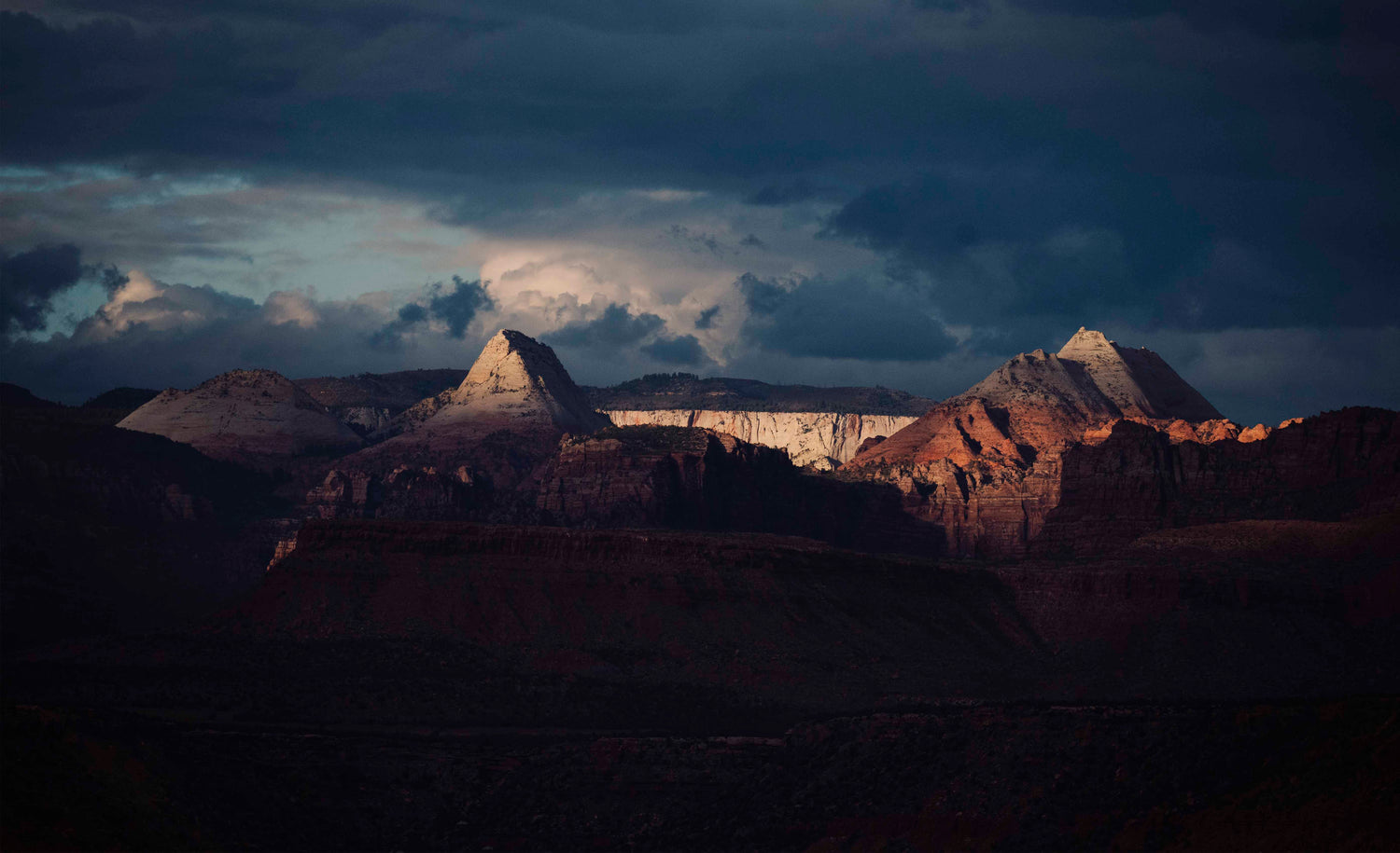 Sunset over a desert landscape with mountains and clouds