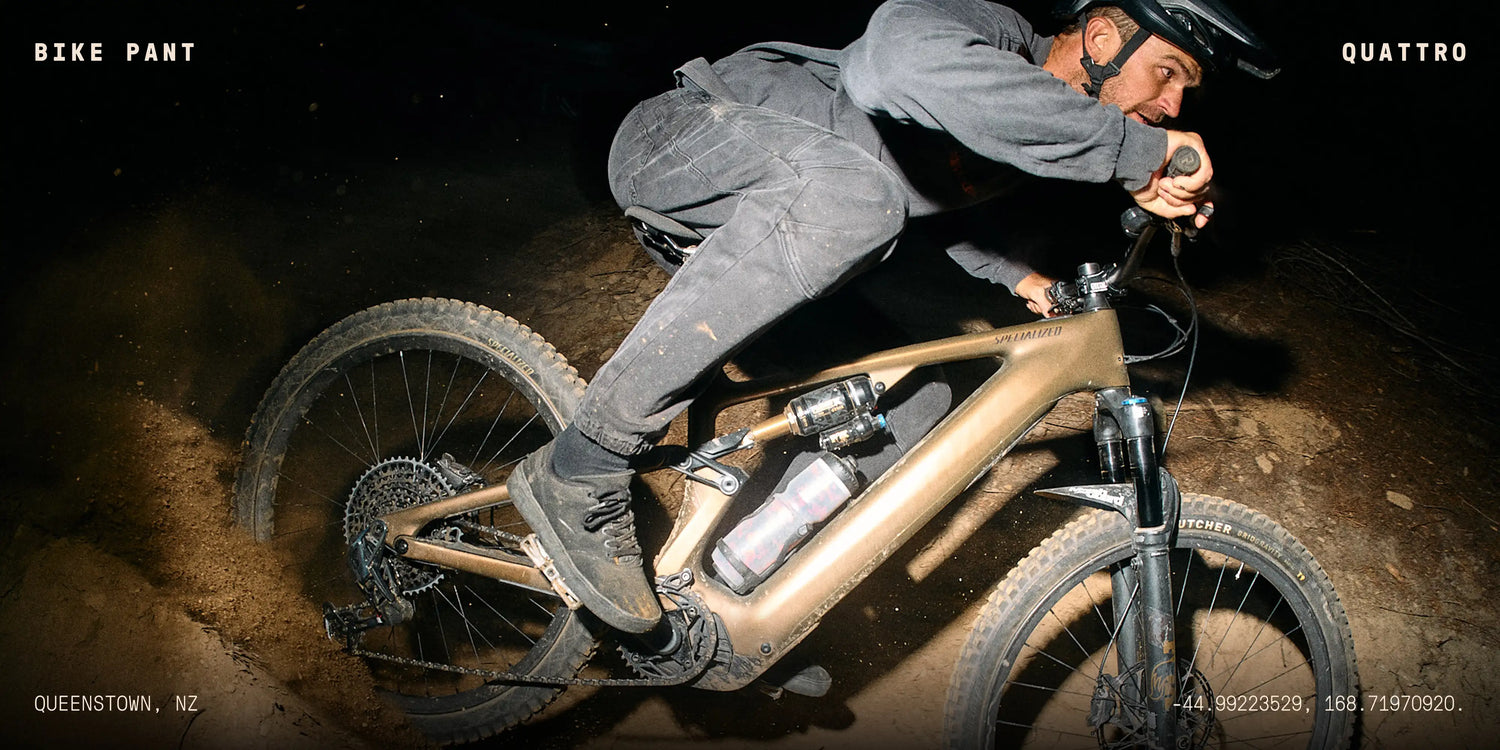Person riding a bike on a dirt path at night with 'Bike Pant' branding.