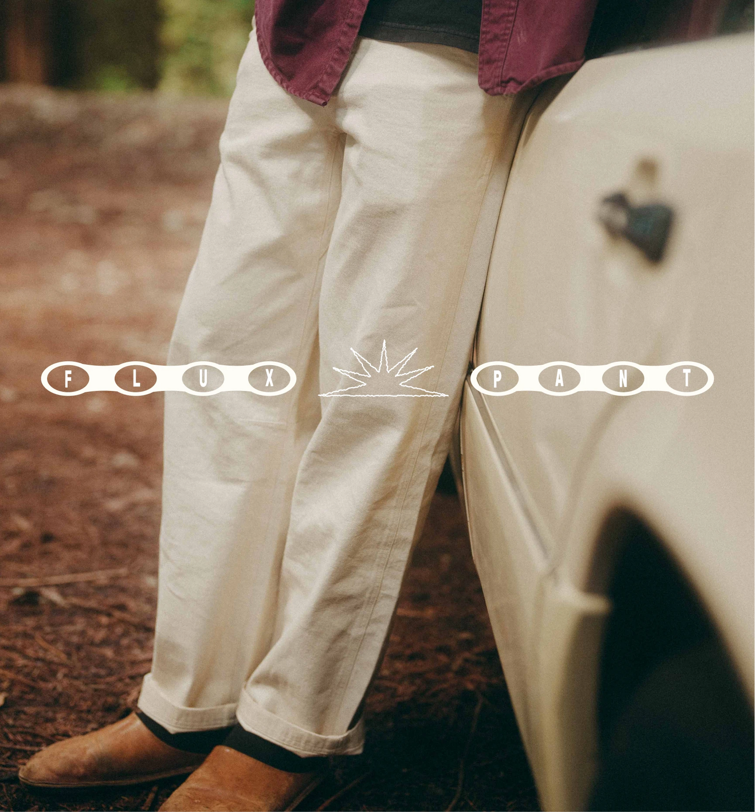 Person wearing white pants with 'Flux Paint' branding in a natural setting.