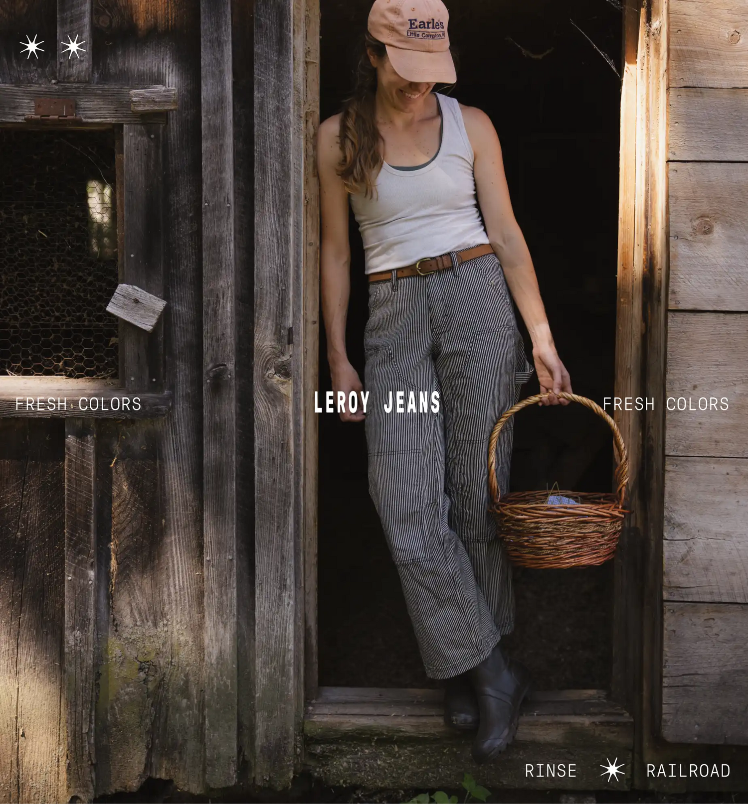 Woman wearing striped pants, white shirt, and orange hat, holding basket leaning against wood doorway. Fresh colors and leroy jeans, rinse railroad, text on the image with white stars. 