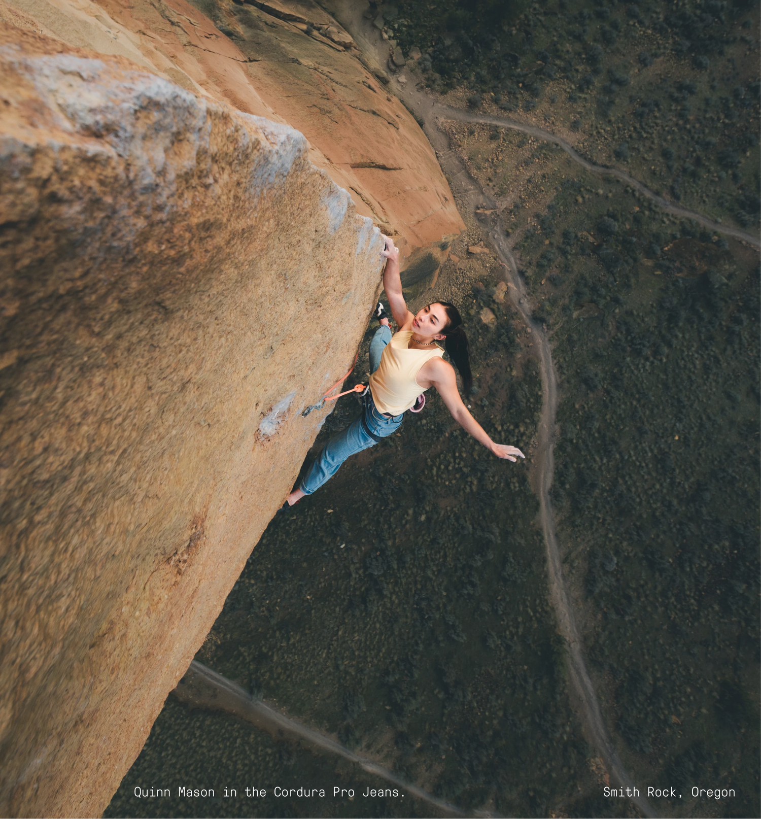 Person climbing a steep rock face with a scenic background