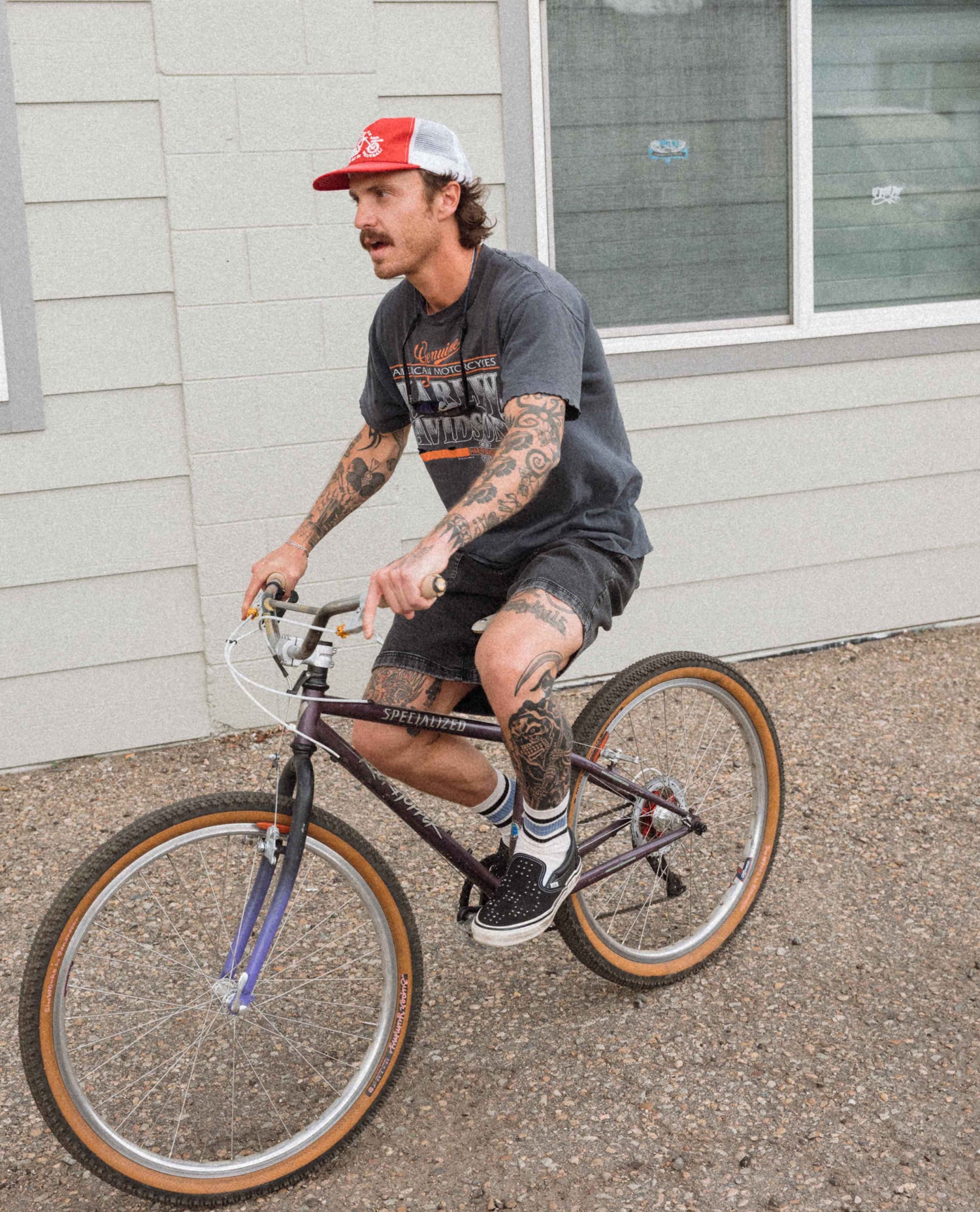 Man riding a bicycle on a sidewalk with a building in the background