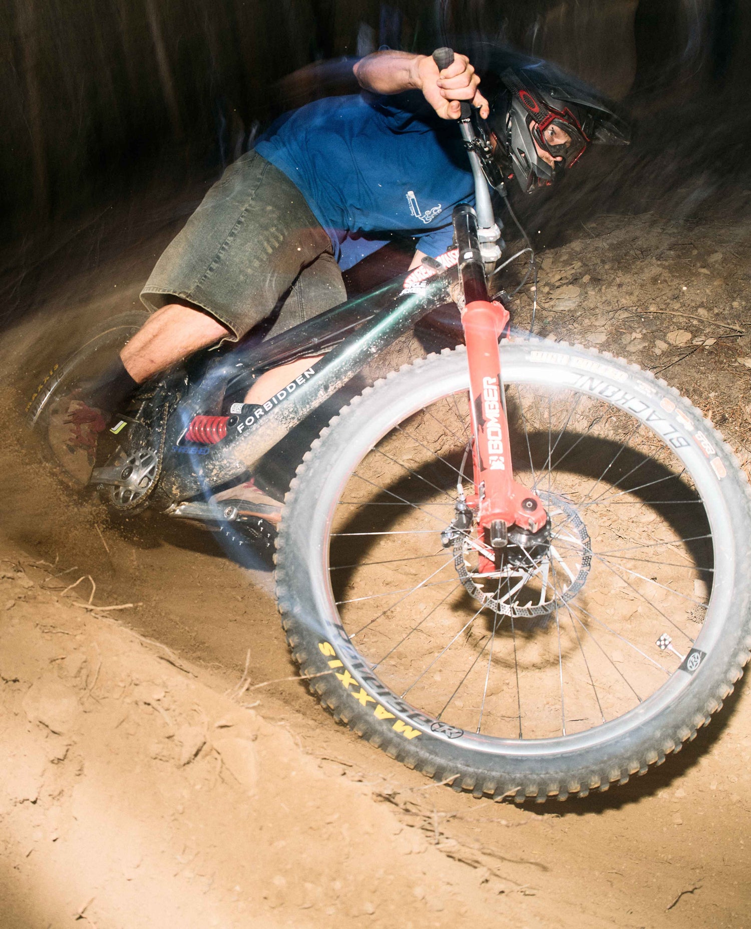 Person riding a mountain bike on a dirt trail at night
