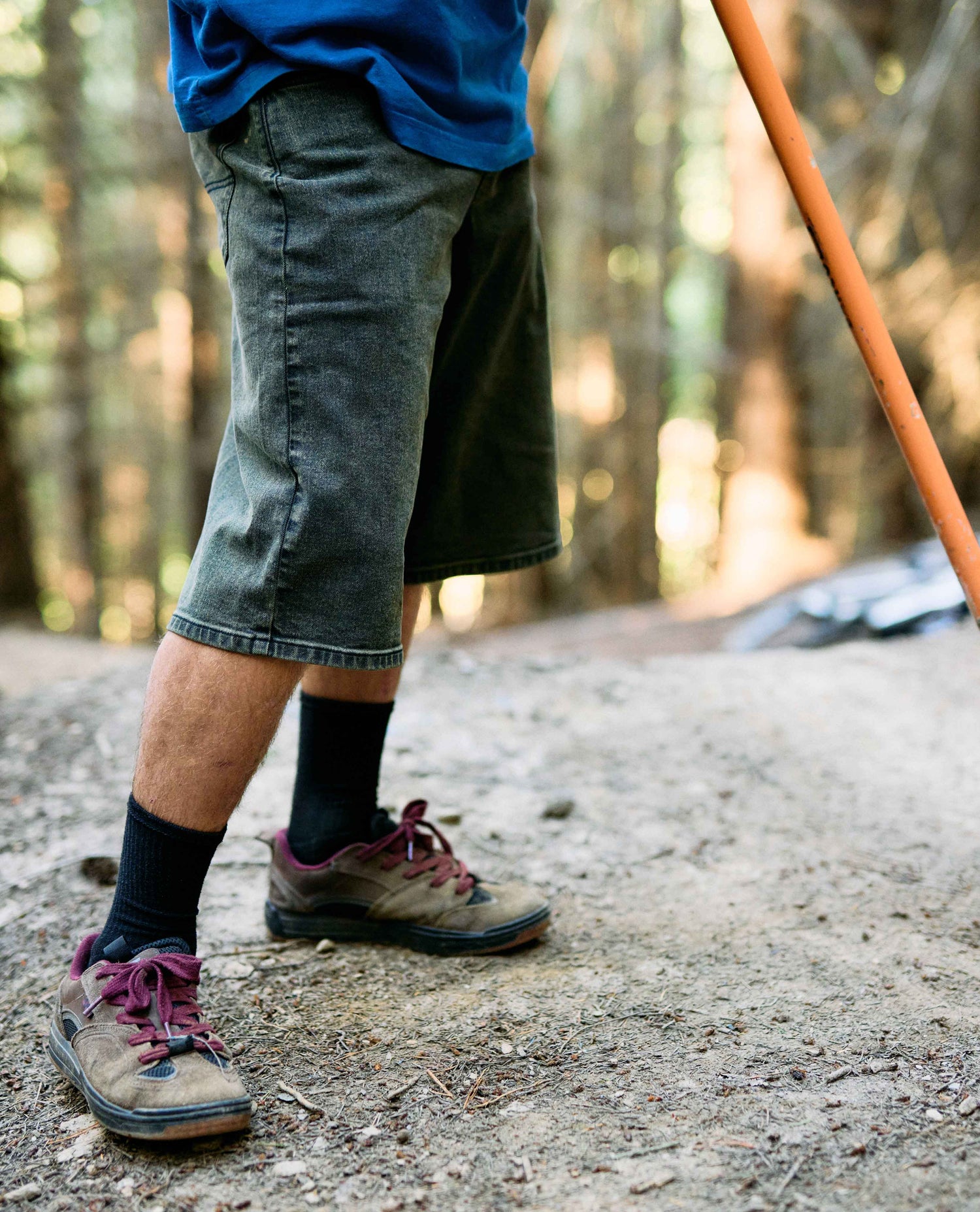 Person wearing hiking shoes and shorts on a forest path